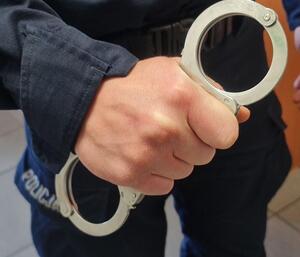 Kajdanki w dłoni policjanta.