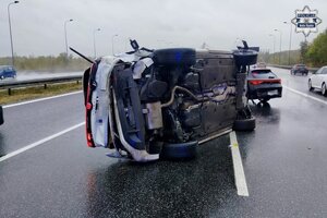 Rozbity samochód leżący na boku na drodze.