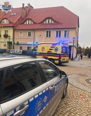 Karetka i radiowóz przy budynku.
