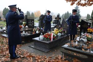 komendant składa wieniec na grobie.