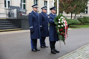 komendant składa wieniec na grobie.