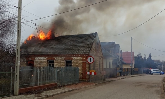 Policjanci razem ze świadkiem wyprowadzili mężczyznę z płonącego budynku