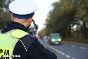 Policjant ruchu drogowego kontroluje prędkość jadących pojazdów.