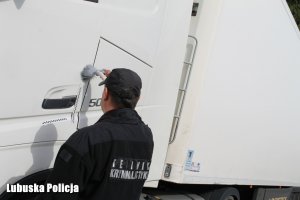 Technik kryminalistyki podczas opylania ciężarówki.