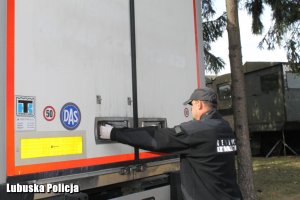 Technik kryminalistki przy naczepie ciężarówki.