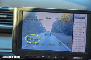 Ekran policyjnego videorejestratora na którym widać pojazd osobowy jadący jezdnią.