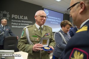 Funkcjonariusz Straży Granicznej z pamiątkowym medalem.