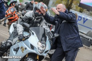 policjant pokazuje drogę motocykliście