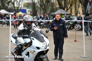 Policjantka mierzy czas motocykliście na torze przeszkód