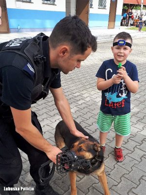 Policjant z psem służbowym. Obok chłopiec