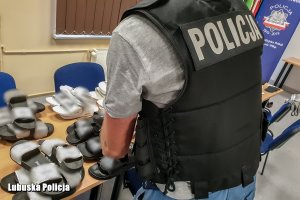 Policjant przegląda podrabiane obuwie