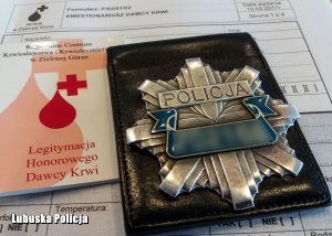 Policyjna odznaka oraz książeczka krwiodawstwa.