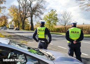 Policjanci ruchu drogowego obserwujący ruch pojazdów na drodze krajowej numer 22