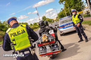 Policjanci ruchu drogowego kontrolujący motocyklistę