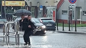 policjant niesie kobietę na rękach