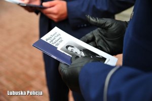 Policjant trzymający broszurę