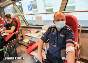 Policjant podczas oddawania krwi w krwiobusie.
