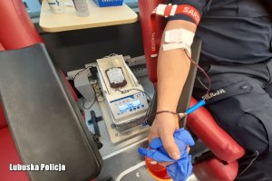 ręka policjanta z podłączeniem do oddawania krwi