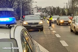 policjant kieruje ruchem ulicznym pokazując jazdę na suwak