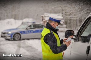 Policjant ruchu drogowego podczas kontroli domunentow kierowcy