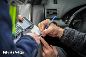 policjantka daje kierowcy mandat do podpisania