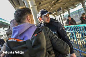 policjanci rozmawiają z osobami na peronie