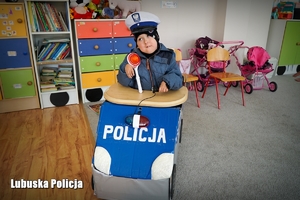 Chłopiec w specjalnie przygotowanym pojeździe z logo policji