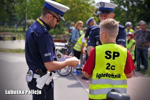 Policjant tłumaczy zasady rowerzyście