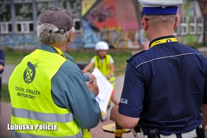 Policjant wraz z organizatorem konkursu obserwują zmagania