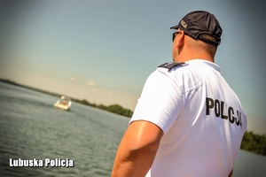 policjant obserwuje płynącą łódź