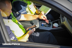 Policjant sprawdza uprawnienia kierowcy