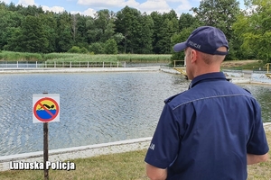 Policjant z brzegu obserwuje zbiornik wodny