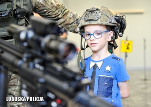 Chłopiec z bronią na pokazie policyjnego sprzętu