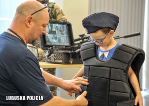 Policjant z chłopcem ubranym w sprzęt policyjny