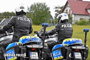 Policjanci jadący policyjnym motocyklem.