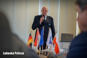 Przemawiający do mikrofonu niemiecki policjant.