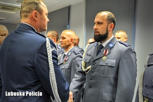 Komendant wręcza medal policjantowi