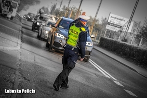 Policjant drogówki podczas kierowania ruchem na drodze.