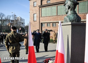 Komendanci służb mundurowych oddają honor przed pomnikiem.