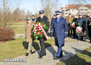 Komendanci służb mundurowych składają kwiaty przed pomnikiem.