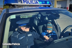 policjantka i chłopiec siedzą w radiowozie