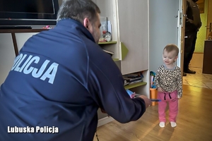 policjant wręcza dziecku słodycze