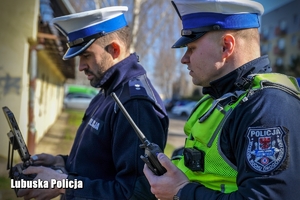 policjant operujący dronem i drugi stojący obok