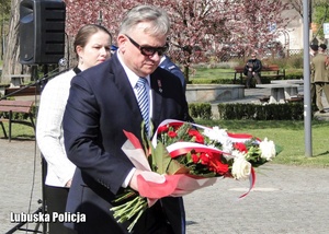 Delegacja osób podczas składania wiązanki kwiatów.