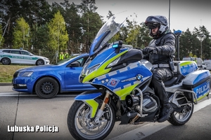 Policyjny motocyklista podczas zatrzymywania pojazdu do kontroli drogowej.
