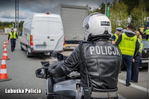 policjant na motocyklu i inni mundurowi w tle