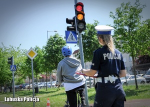 Policjantka z rowerzysta przed sygnalizatorem.