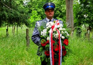 Policjant z pocztu sztandarowego z wieńcem