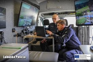 policjanci siedzą w samochodzie technicznym