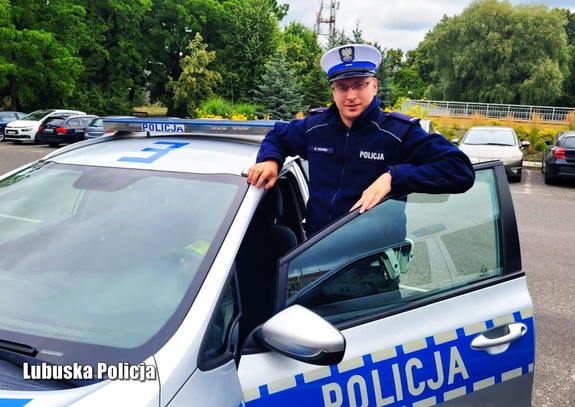 Policjant ruchu drogowego przy radiowozie